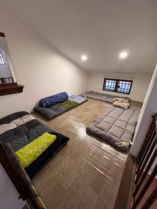a room with three beds in the middle of it at Big Dreams Double Story House in Tanah Rata