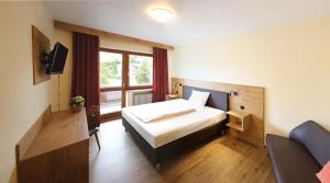 a hotel room with a bed and a window at Landgasthof Baumgartner in Dingolfing