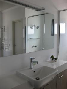 a white bathroom with a sink and a mirror at Hartzell One Seven in Metricup