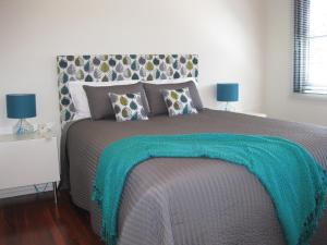 a bedroom with a bed with a green blanket on it at Hartzell One Seven in Metricup