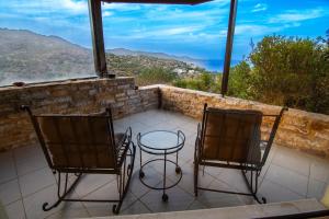 two chairs and a table on a balcony with a view at Cicada 4 Bedroom Villa in Palaiokastro