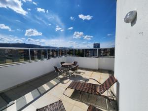 a balcony with a table and chairs on a building at Rooftop 402: cobertura de um quarto no centro in Sete Lagoas