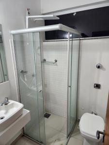 a bathroom with a shower and a toilet and a sink at Rooftop 402: cobertura de um quarto no centro in Sete Lagoas
