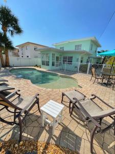 una piscina con sedie e tavolo e una casa di Cozy Canaveral Cottages a Cape Canaveral