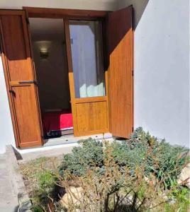 an open door of a building with a red bed at Alpine House in Sauze dʼOulx