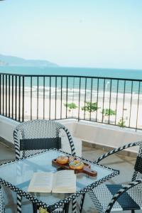 a table with two chairs and a table with two books at Anstay Beach Da Nang in Da Nang