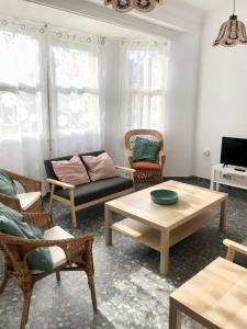 sala de estar con sofá, sillas y mesa en El Chalet Amarillo en Cabañas