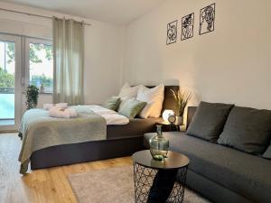 een woonkamer met een bed en een bank bij Design Apartment mit Balkon - Küche - Netflix in Essen