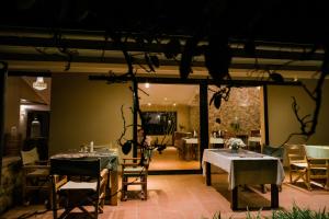 a dining room with tables and chairs and a television at Domiya Estate Ltd in Dodoma