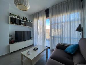 a living room with a couch and a large window at Luxury House Villamartin Zenia in Alicante