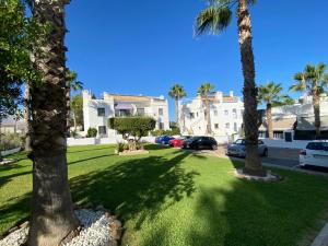 un césped con palmeras en un barrio residencial en Luxury House Villamartin Zenia en Alicante