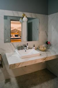 y baño con lavabo blanco y espejo. en Domiya Estate Ltd, en Dodoma