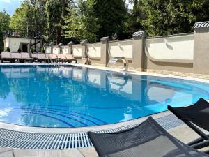 a large swimming pool with chairs and blue water at Apartment Eney in Lviv