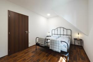 a bedroom with a bed and a wooden floor at Apartmány Depandace Anička in Deštné v Orlických horách
