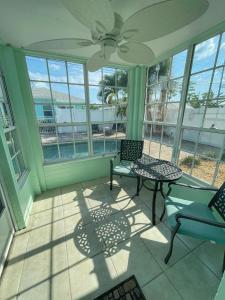 una veranda schermata con 2 sedie e un tavolo di Cozy Canaveral Cottages a Cape Canaveral