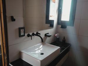 y baño con lavabo blanco y espejo. en RevolucionArte Potrerillos en Luján de Cuyo
