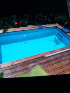 a swimming pool on a wooden deck with a blue water at BIENVENUE AU SOLEIL LEVANT assier entrée morne savon ,le lorrain in Le Lorrain