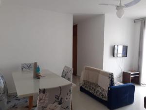 a living room with a white table and chairs at apartamento praia dos milionarios in Ilhéus