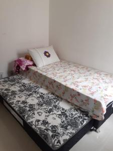 a bed with a black and white comforter at apartamento praia dos milionarios in Ilhéus