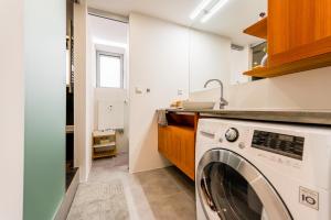 a laundry room with a washer and a sink at Luxury Apartment in the City Centre in Košice