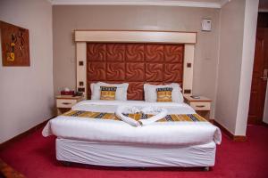 Postel nebo postele na pokoji v ubytování The Luke Hotel Cravers Thika