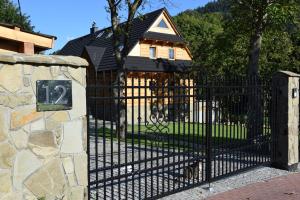 a black gate in front of a house at Willa Góralka in Szczyrk