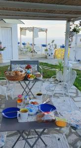 a picnic table with food and drinks on it at Message in a Bottle Bed and Breakfast in Camporosso
