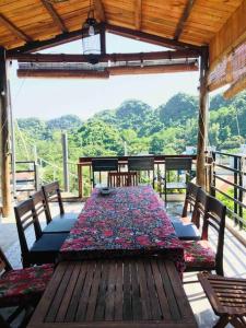 uma mesa de madeira e cadeiras num quarto com vista em Chez Phuong Cat Ba -Private entire house em Ilha de Cát Bà