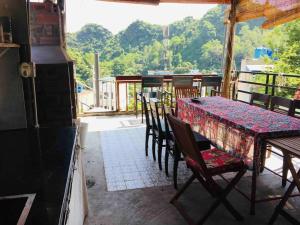 uma mesa e cadeiras sentadas num alpendre com uma mesa e uma mesa e cadeiras em Chez Phuong Cat Ba -Private entire house em Ilha de Cát Bà