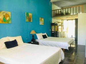 Duas camas num quarto com paredes azuis em Chez Phuong Cat Ba -Private entire house em Ilha de Cát Bà
