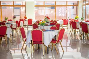 a dining room with tables and chairs with flowers on them at The Luke Hotel Cravers Thika in Thika