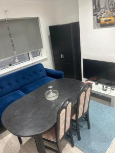 - un salon avec une table et un canapé bleu dans l'établissement Just Plan B Homes, à Forest Hill