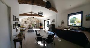 a kitchen and living room with a table and chairs at La villa du pressoir, classé 3 étoiles meublé de tourisme in Le Pallet