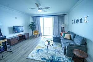 ein blaues Wohnzimmer mit einem Sofa und einem TV in der Unterkunft Orlando Apt 9th Floor 5 min from Disney in Orlando