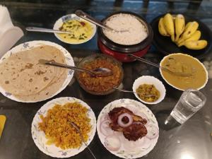 a table topped with different types of food on plates at Venitia Homestay in Alleppey