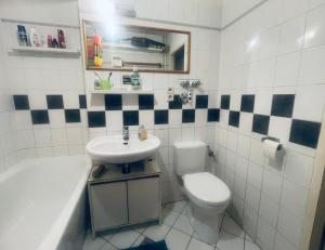 Un baño con lavabo, inodoro y bañera. en Alt Treptow Fashion HQ, en Berlín