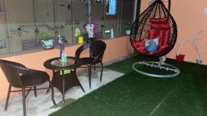 a room with chairs and a table and a swing at Terrace garden & Unique 1 bedroom AC rental unit in Haldia in Haldia +6 photos