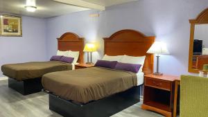 a hotel room with two beds with purple pillows at Budget Inn Express in South Hill
