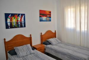 Un dormitorio con dos camas y un cuadro en la pared. en Apartamento Benicasim 1ª línea de playa, en Benicàssim 14 fotos más