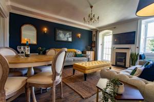 a living room with a table and a living room with a couch at Georgian House Garden Apartment in Bath