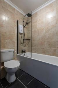 a bathroom with a toilet and a tub and a shower at Georgian House Garden Apartment in Bath