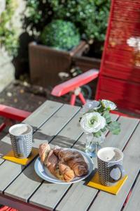 a table with a plate of croissants and two cups at Georgian House Garden Apartment in Bath