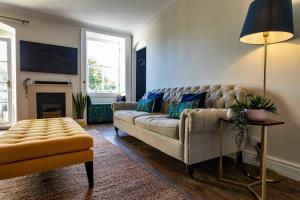 a living room with a couch and a table at Georgian House Garden Apartment in Bath