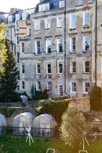 a group of domes in a yard in front of a building at Georgian House Garden Apartment in Bath