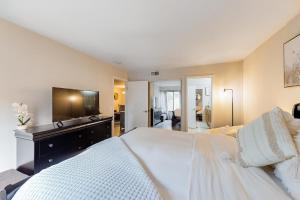 a bedroom with a large white bed and a television at Pacific Cove Unit 111 in Los Angeles +14 photos