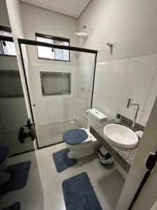 La salle de bains est pourvue de toilettes, d'un lavabo et d'une douche. dans l'établissement Casa 05 Dona D. PX A JK, à Palmas