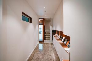 un pasillo de una casa con paredes blancas y una escalera en Stay Ccassette Player, en Mokpo
