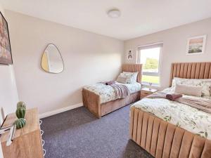 een slaapkamer met 2 bedden en een spiegel bij Modern 5 Bedroom Townhouse with Free Parking in Glasgow