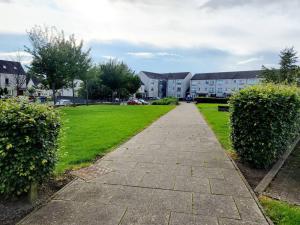 a walkway in a park with houses in the background at Modern 5 Bedroom Townhouse with Free Parking in Glasgow