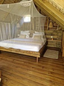 a bedroom with a bed with a mosquito net at PURA VIDA Lodge Cabane perchée in Sainte-Rose